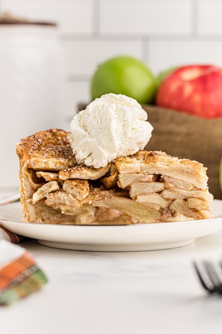 Side view of apple pie slice on plate with ice cream