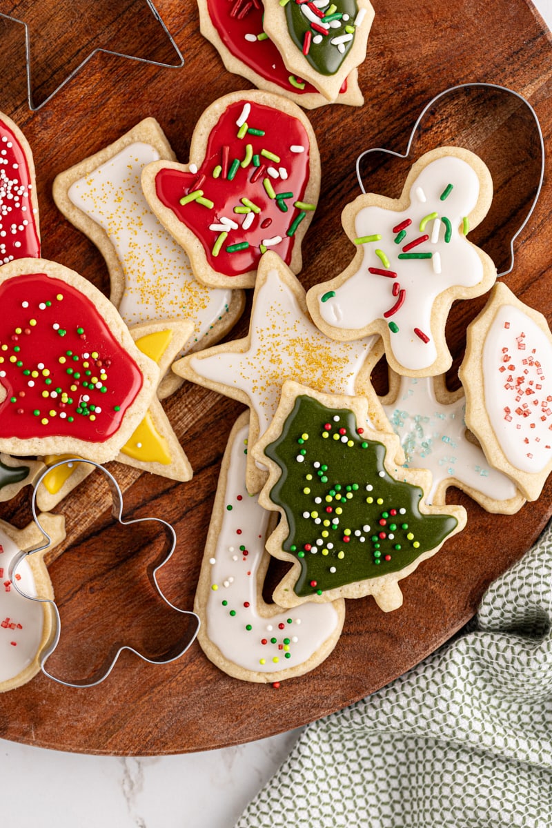 overhead view of several cut-out sugar cookies on a wooden board