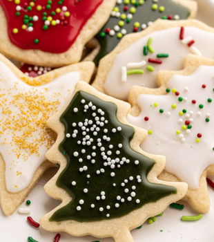 a white plate filled with Christmas cut-out sugar cookies