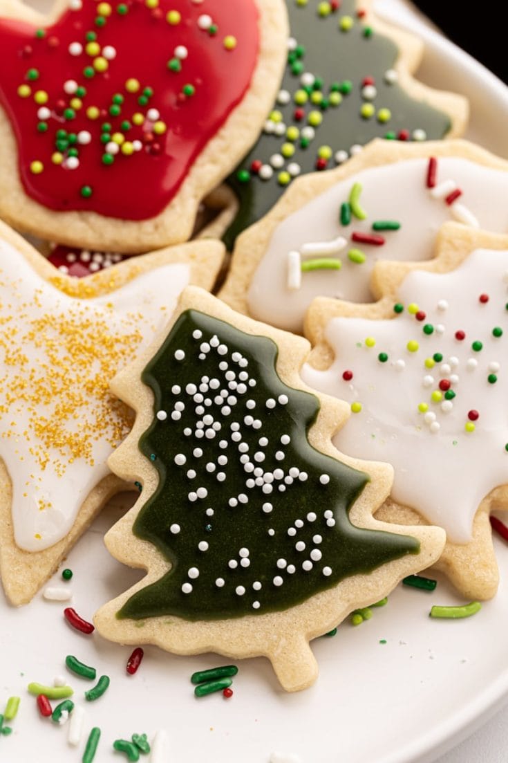 a white plate filled with Christmas cut-out sugar cookies