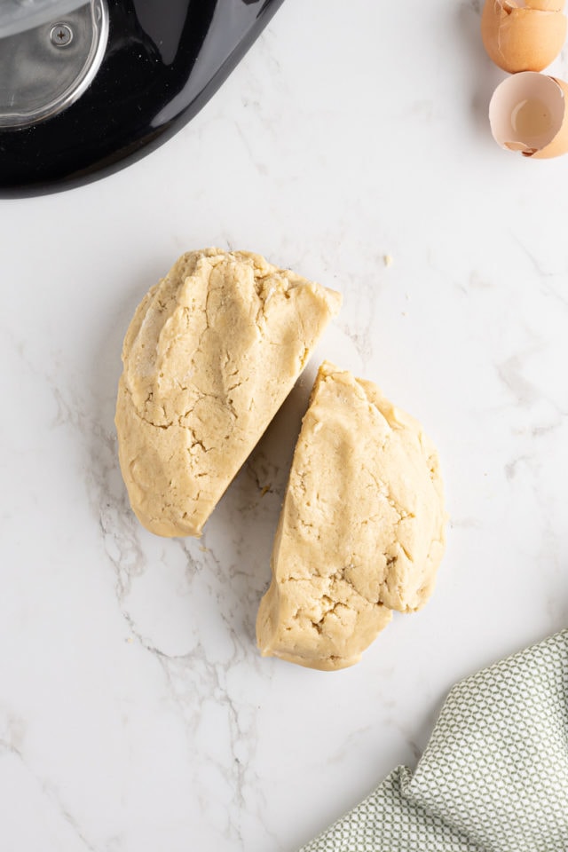 overhead view of cut-out sugar cookie dough divided in half