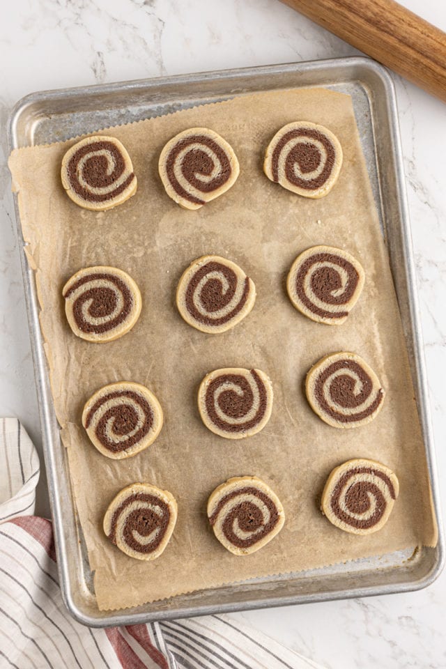overhead view of pinwheel cookie dough on a parchment-lined baking sheet