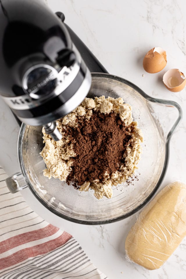 overhead view of cocoa powder and espresso powder added to vanilla cookie dough