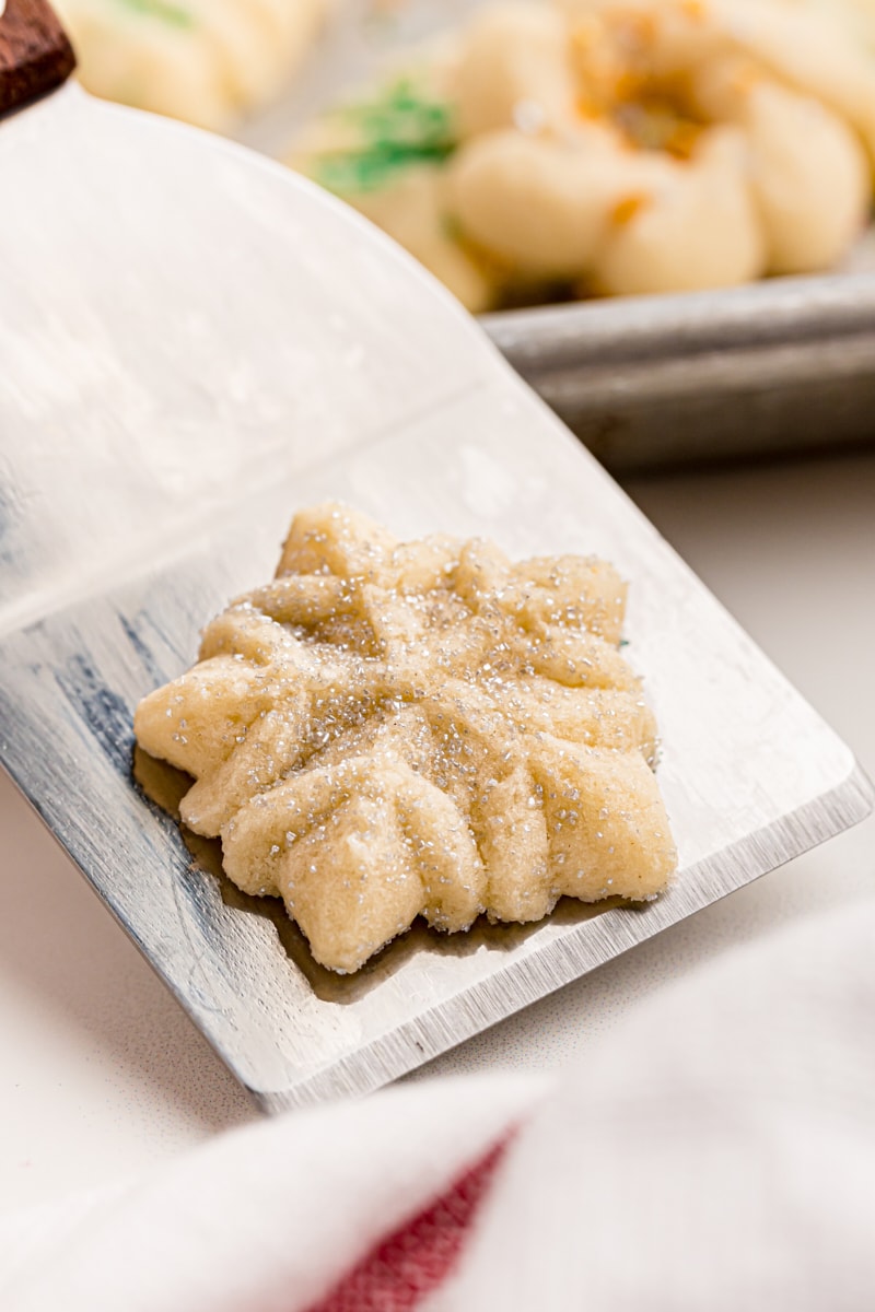 a snowflake-shaped spritz cookie on a cookie spatula