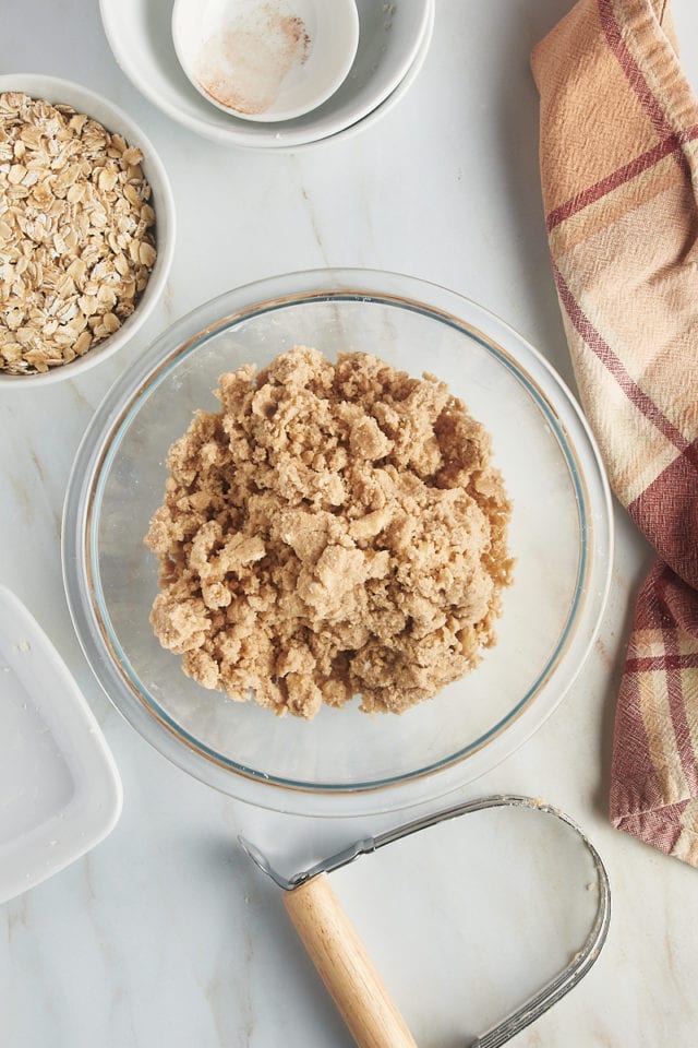 overhead view of partially mixed crumb topping in a glass mixing bowl