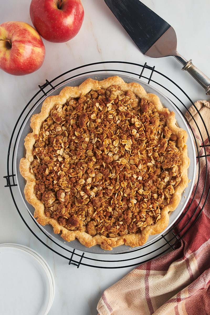 overhead view of freshly baked apple crumb pie on a round wire rack