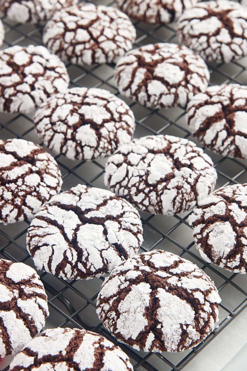 Chocolate crinkle cookies on a wire cooling rack.