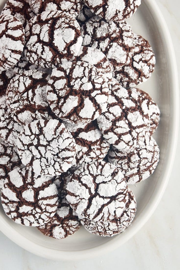 overhead view of chocolate crinkle cookies on a white serving tray