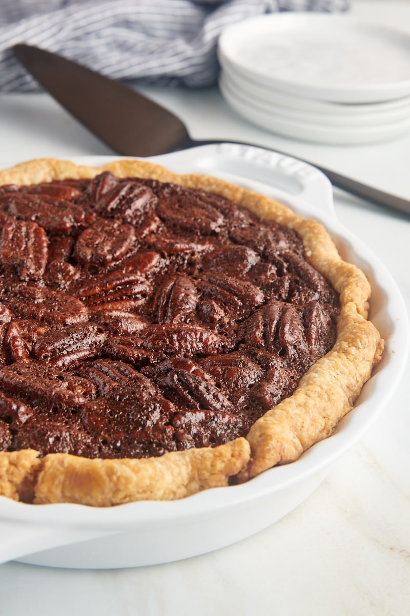 chocolate pecan pie in a white pie plate