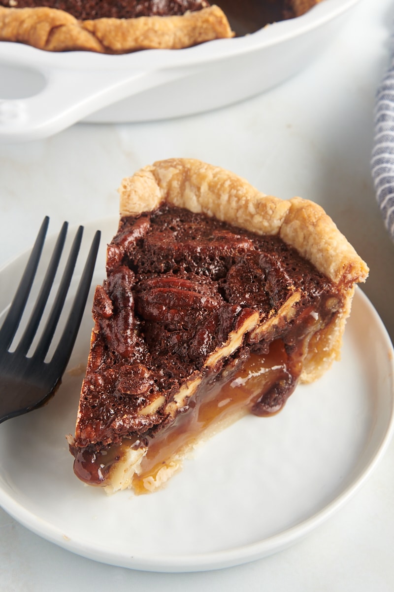 a slice of chocolate pecan pie on a white plate