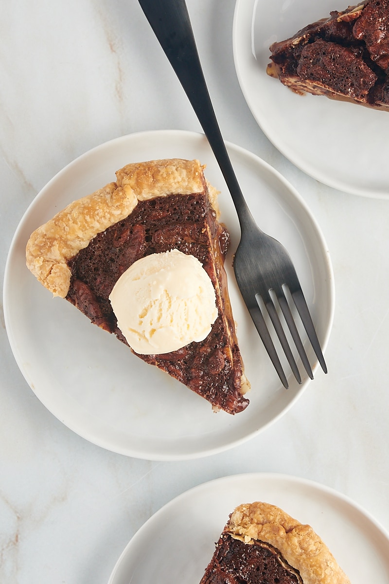 overhead view of a slice of chocolate pecan pie topped with vanilla ice cream