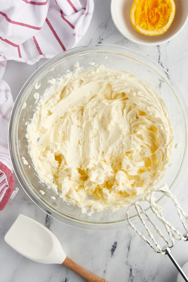 overhead view of beaten cream cheese, sugar, and orange juice in a mixing bowl