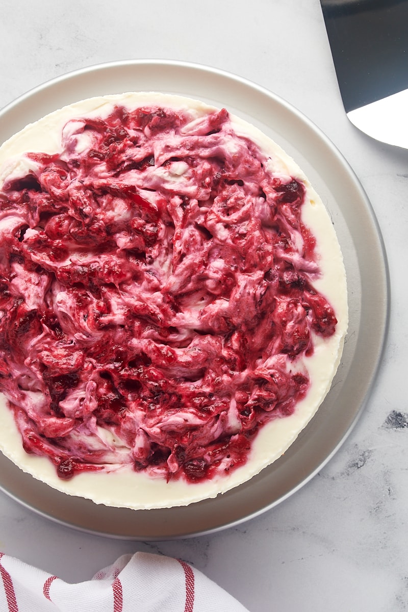 overhead view of no-bake cranberry cheesecake on a metal serving plate