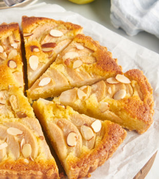 Whole pear frangipane tart on parchment-lined board