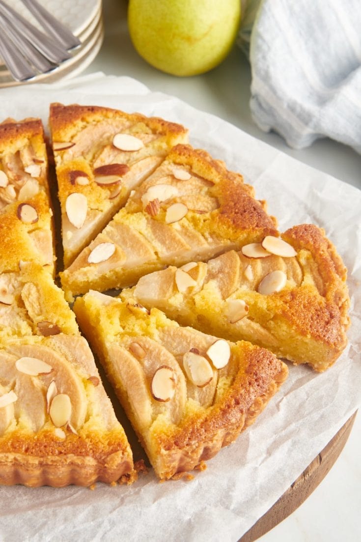 Whole pear frangipane tart on parchment-lined board
