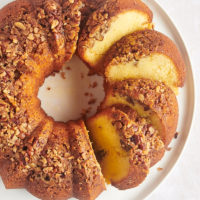 Overhead view of partially cut rum cake on platter