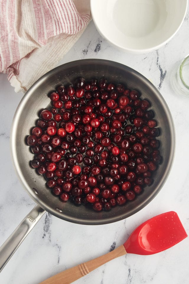 overhead view of cranberries added to simple syrup in a saucepan