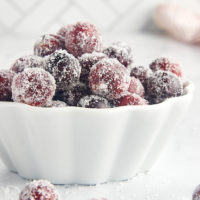 a white bowl filled with sugared cranberries