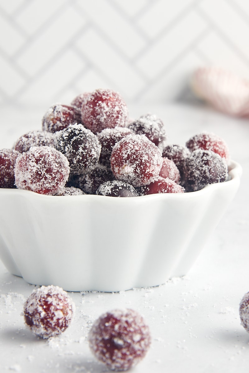 a white bowl filled with sugared cranberries