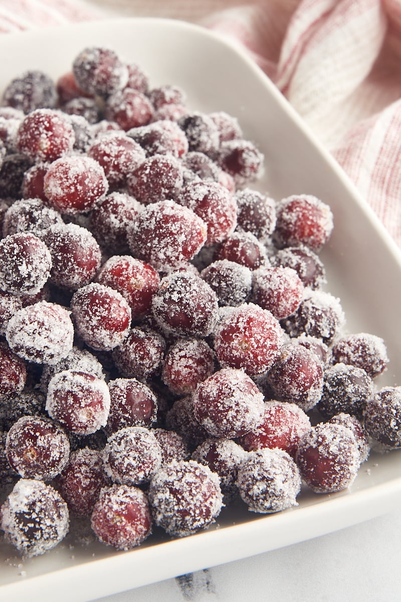 a white tray filled with sugared cranberries