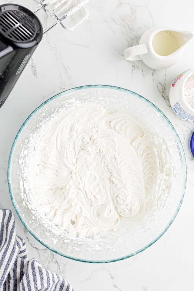 overhead view of marshmallow frosting in a glass mixing bowl