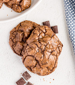 Overhead view of outrageous chocolate cookies stacked on countertop with chocolate chunks
