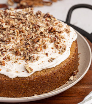 Whole pecan cake with rum frosting on cake plate