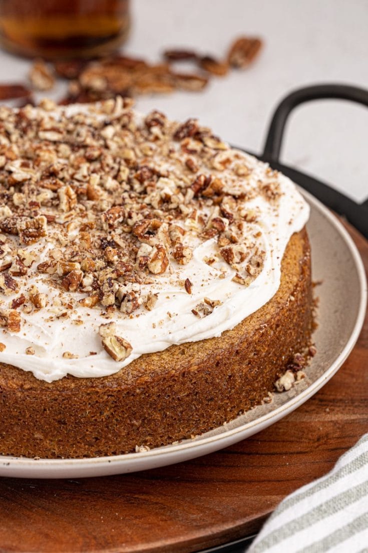 Whole pecan cake with rum frosting on cake plate