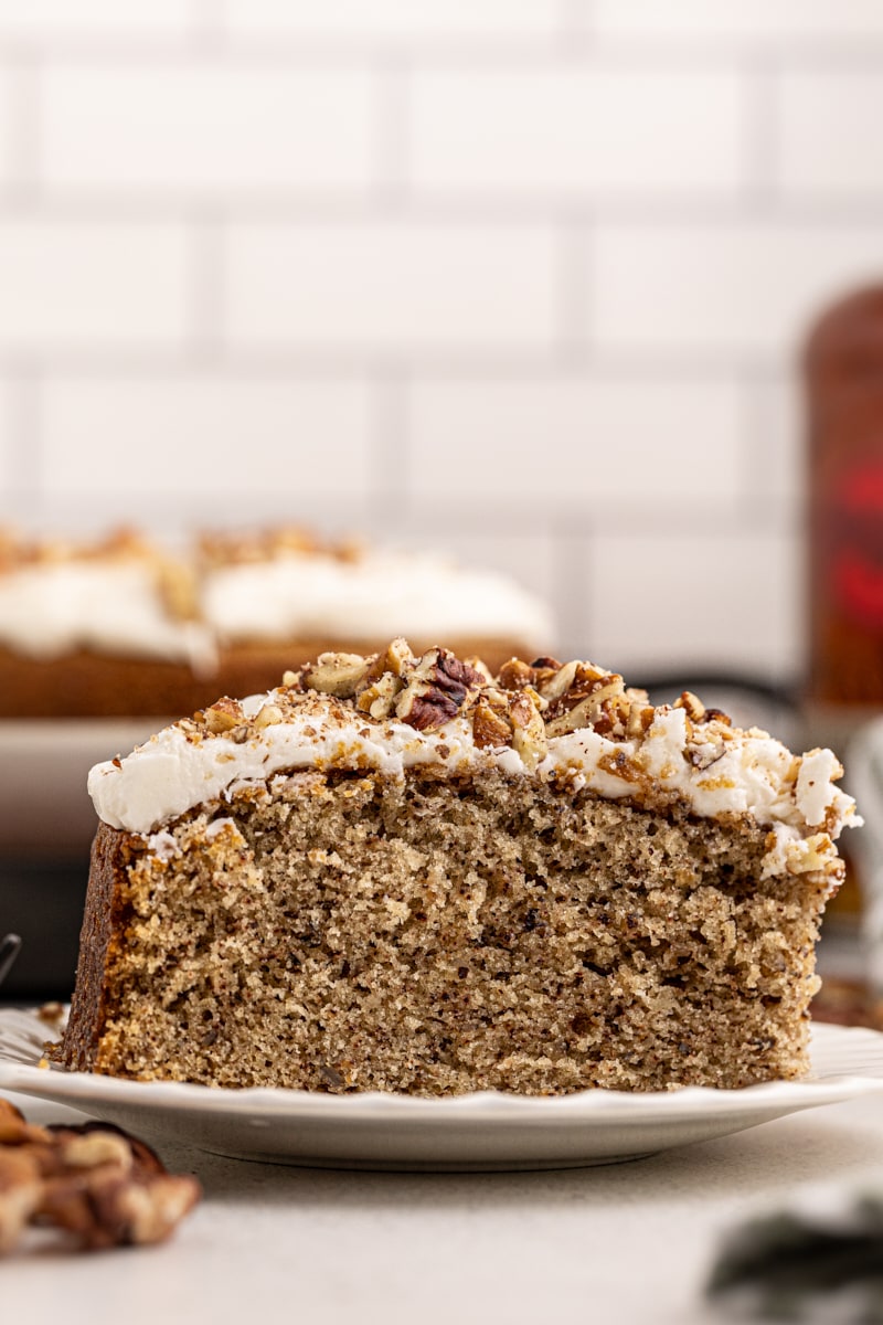 Side view of pecan cake with rum frosting on plate, showing height