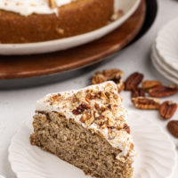 Slice of pecan cake with rum frosting on white plate