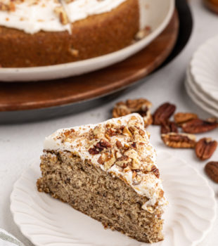 Slice of pecan cake with rum frosting on white plate