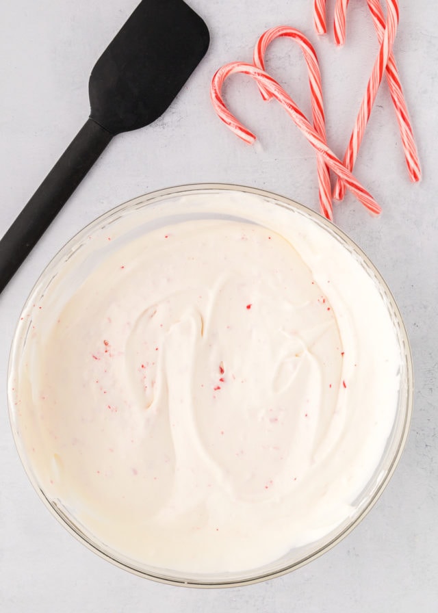 overhead view of mixed peppermint ice cream in a glass mixing bowl