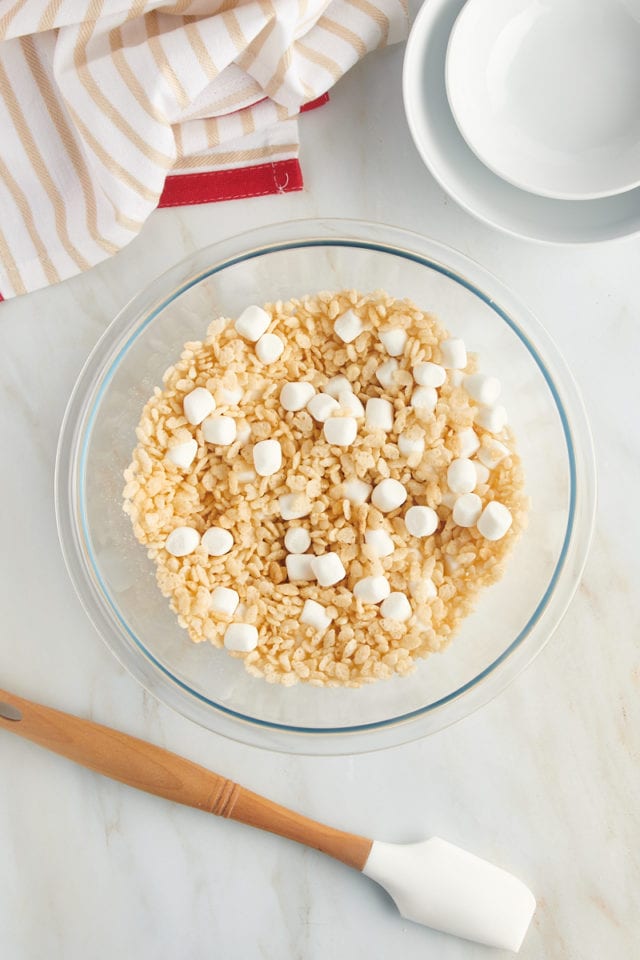 overhead view of rice cereal and mini marshmallows mixed in a glass bowl