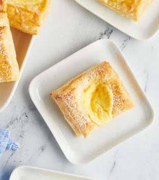 Overhead view of cheese danishes on square plates and tray