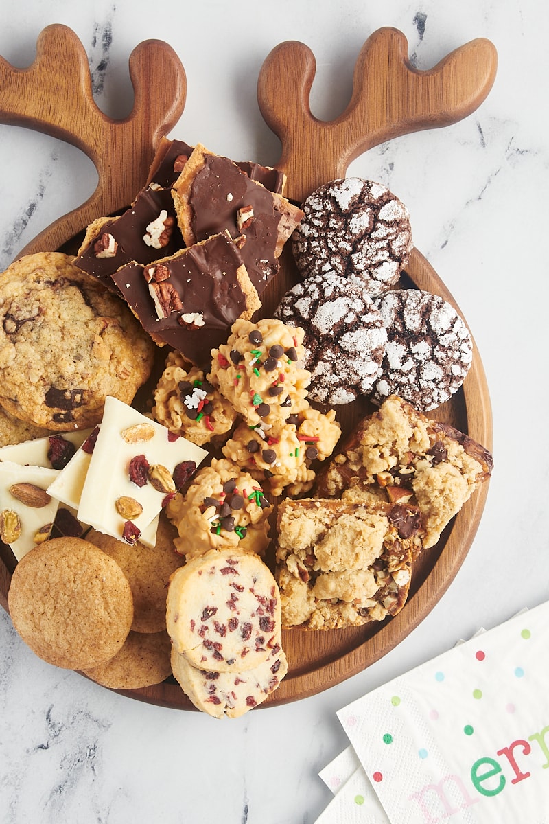 overhead view of various cookies and candies arranged on a wooden board