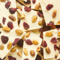 overhead view of cranberry pistachio bark pieces piled on a wooden board