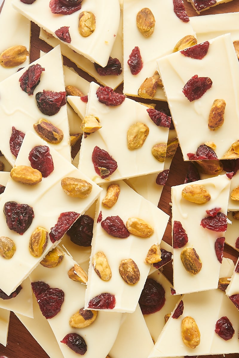 overhead view of cranberry pistachio bark pieces piled on a wooden board