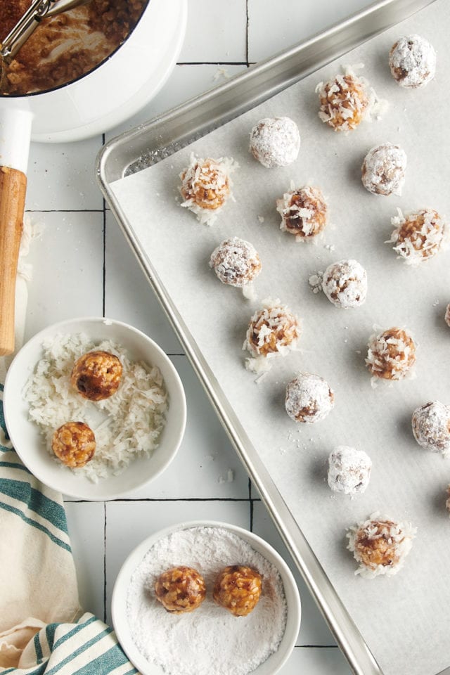 Overhead view of Rice Krispie date balls being rolled in powdered sugar and coconut