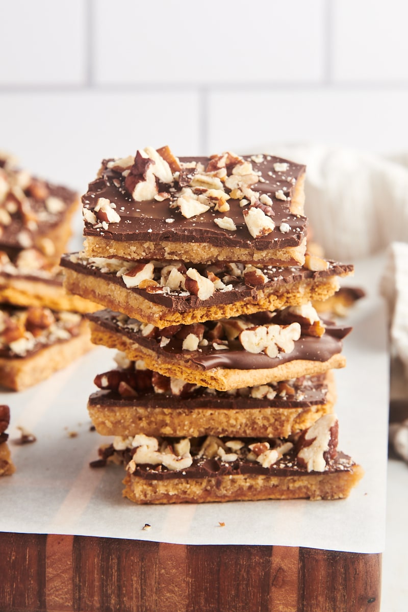 a stack of five pieces of graham cracker toffee with more toffee in the background