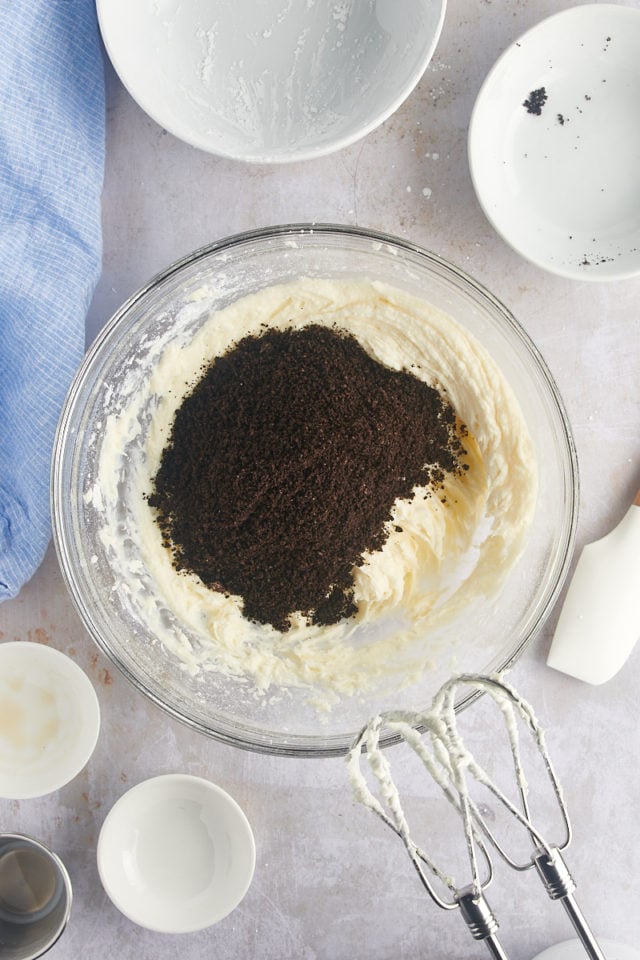 Overhead view of Oreo crumbs added to bowl of frosting