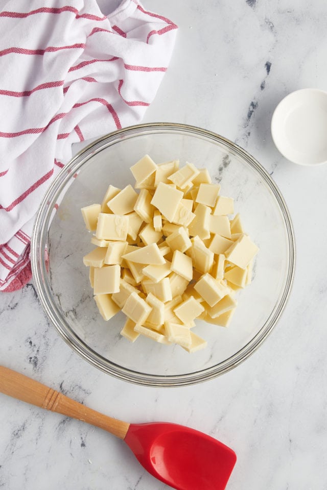overhead view of chopped white chocolate in a glass mixing bowl