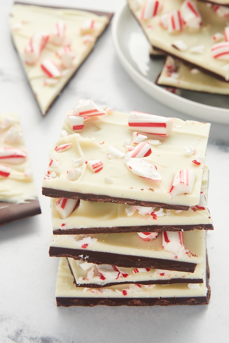 five pieces of peppermint bark stacked together with more bark in the background