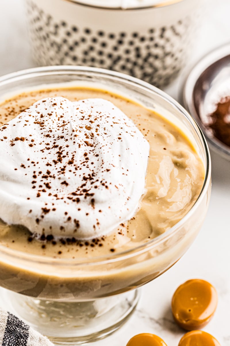 Butterscotch pudding topped with whipped cream and cocoa powder