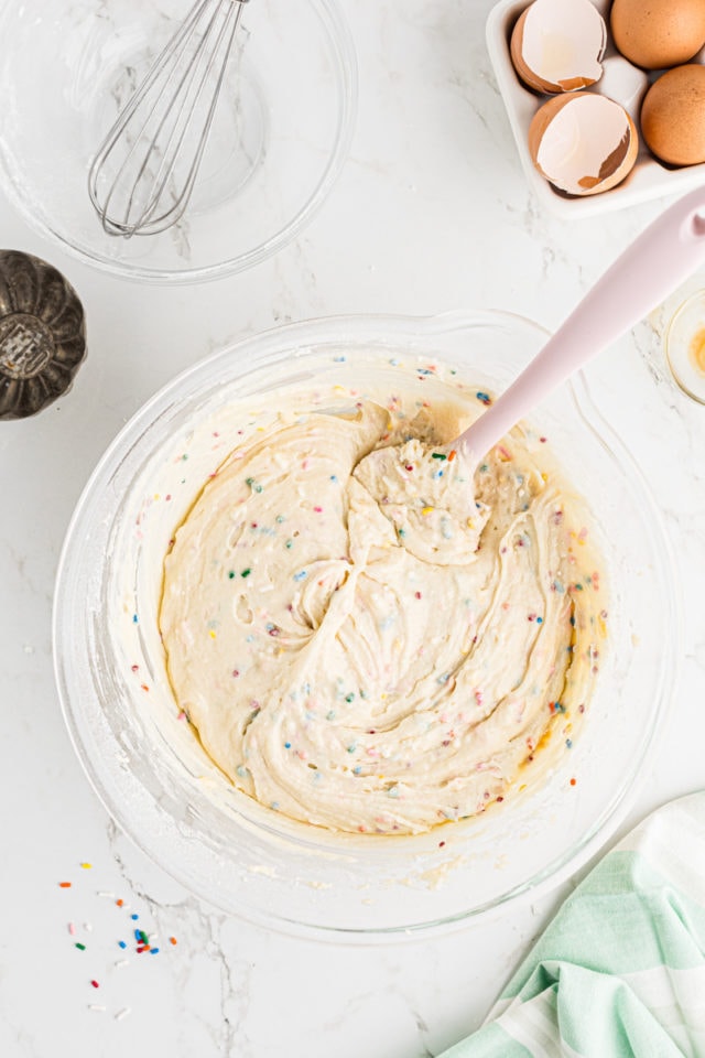 overhead view of confetti cupcake batter in a glass mixing bowl