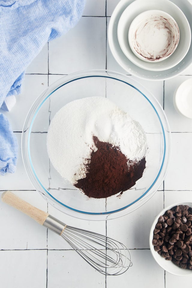Overhead view of cocoa powder, flour, salt, baking soda, and baking powder in mixing bowl