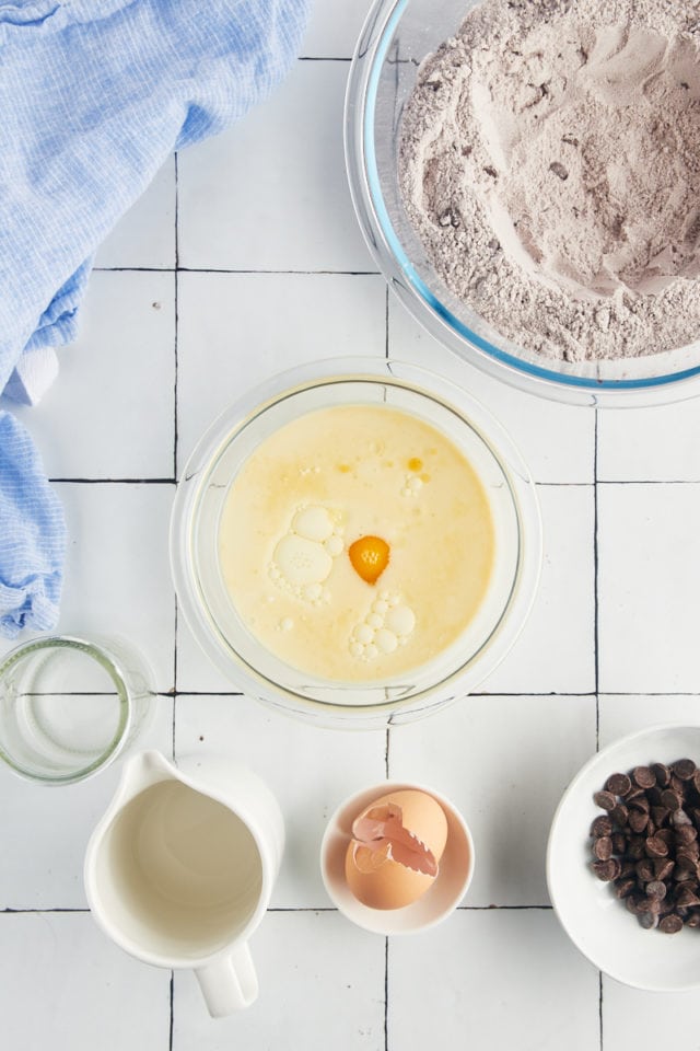 Overhead view of egg, oil, and milk in bowl before whisking
