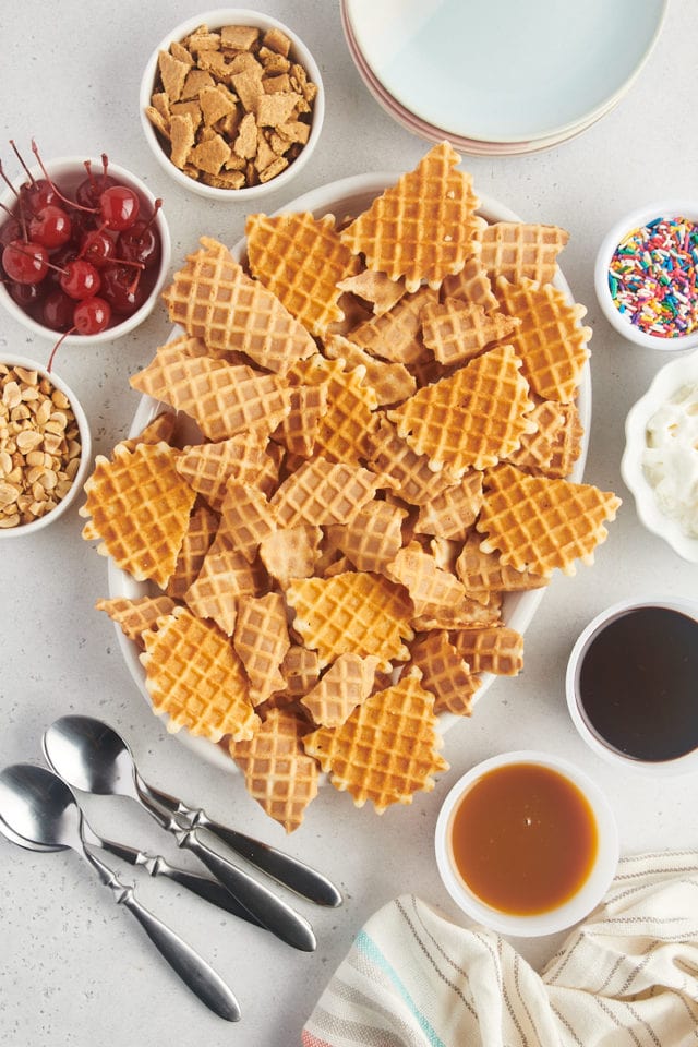 overhead view of broken waffle cones layered on a white oval platter