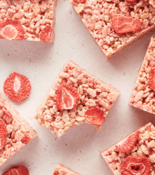 a strawberry rice crispy treat with a bite missing surrounded by more treats