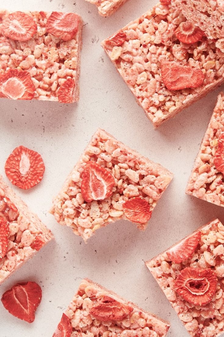 a strawberry rice crispy treat with a bite missing surrounded by more treats
