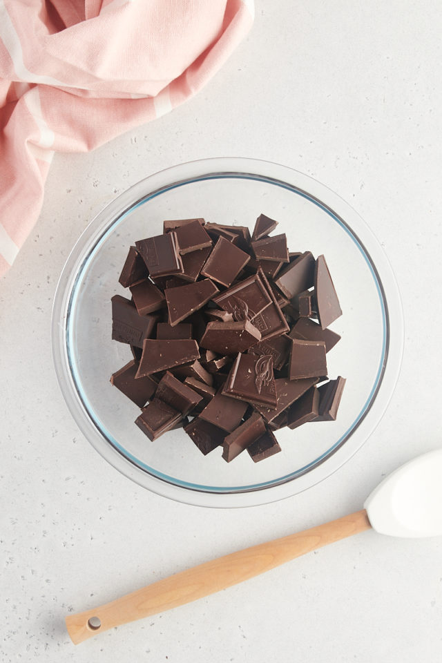 overhead view of dark chocolate pieces in a glass bowl
